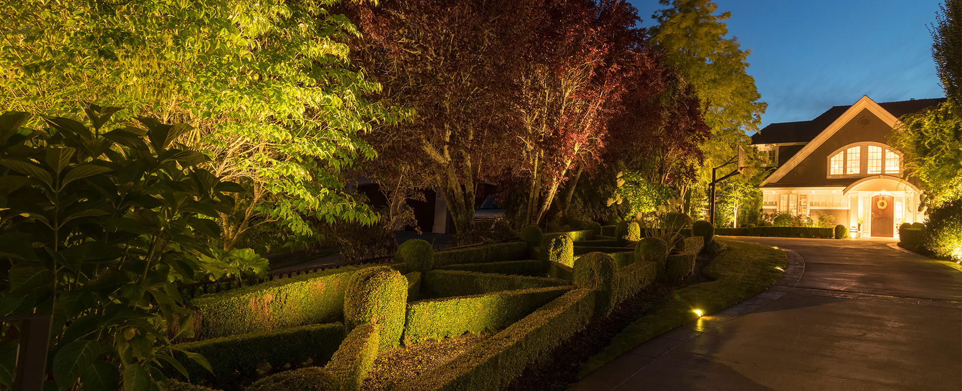 A Medina, WA home entrance with beautiful foliage is illuminated by Northwest Outdoor Lighting.