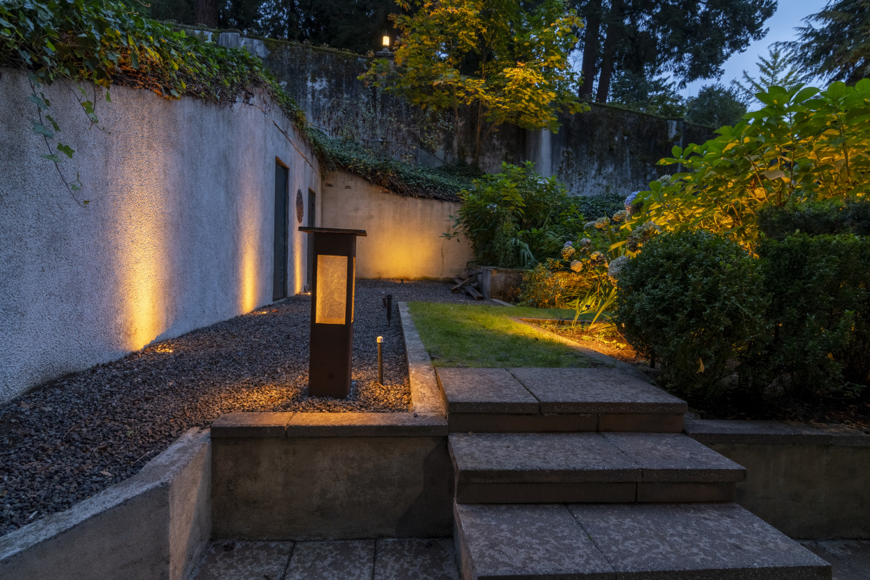 The Rook pathway lighting and stone stair illumination along retaining wall for safe guest access at this luxury Shoreline estate.