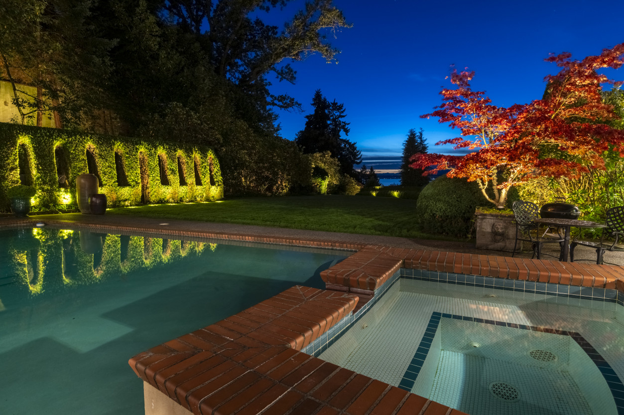 Pool and spa lighting creating resort-style nighttime ambiance with warm LED accents surrounding outdoor living areas.