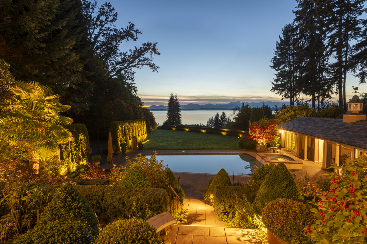 Warm LED path and stair lighting leading down to the luxury pool area with expansive waterfront views at The Highlands Estate in Shoreline, WA.