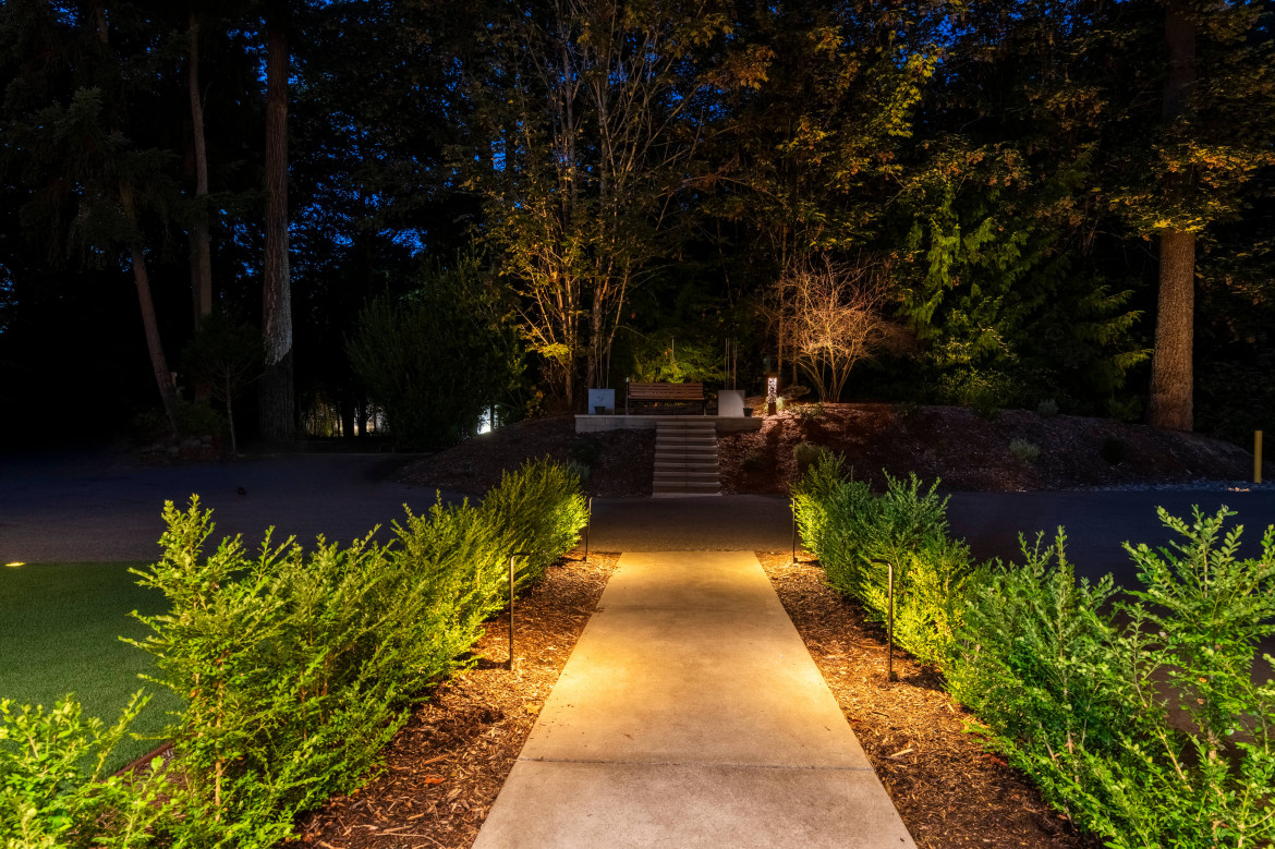 Evening pathway lighting leading from driveway to entry surrounded by structured hedges at a Mercer Island Contemporary Estate.
