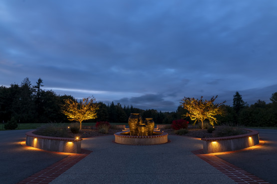 Wide view of a circular driveway and landscape walls accented with Sunset Tone lighting at an Auburn residence designed with 128 total fixtures.