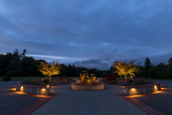 Wide view of a circular driveway and landscape walls accented with Sunset Tone lighting at an Auburn residence designed with 128 total fixtures.