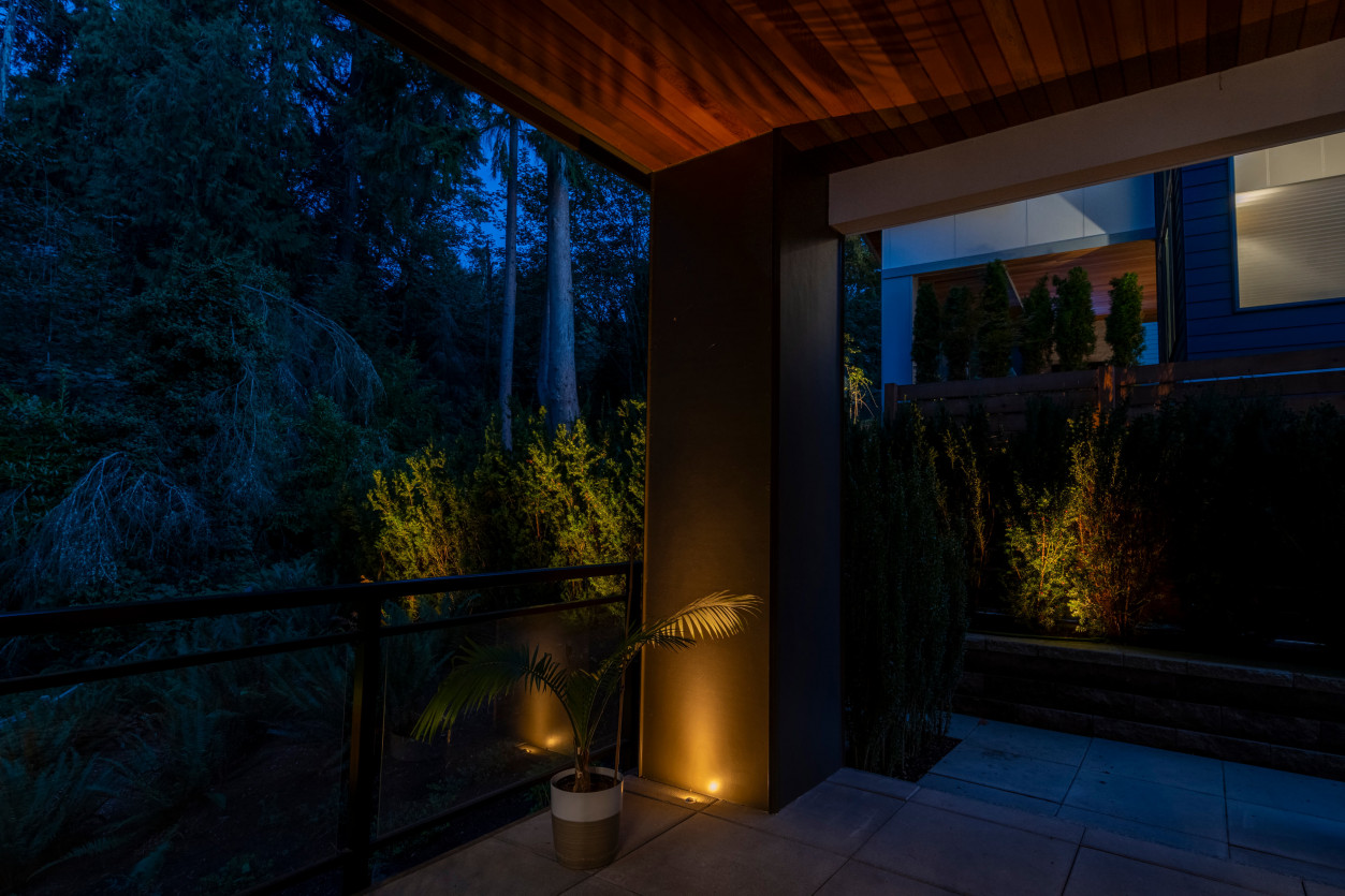 Architectural column uplighting highlighting wood soffit and outdoor railing at a Mercer Island modern residence.