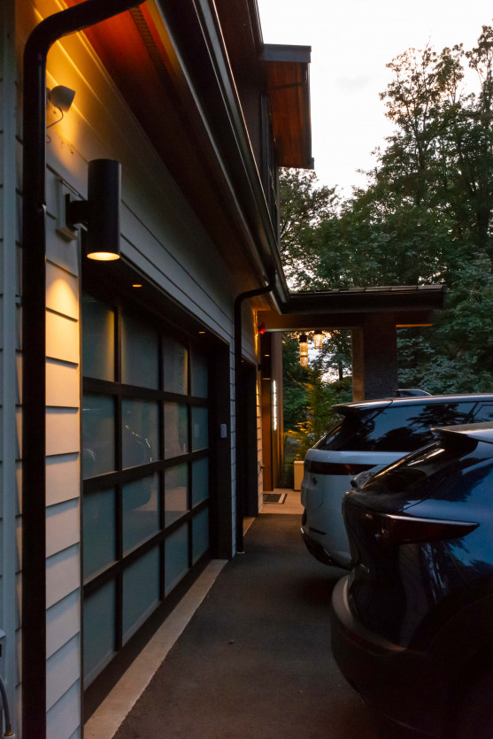 Garage exterior lighting illuminating architectural siding and driveway entry for nighttime safety at a Mercer Island estate.