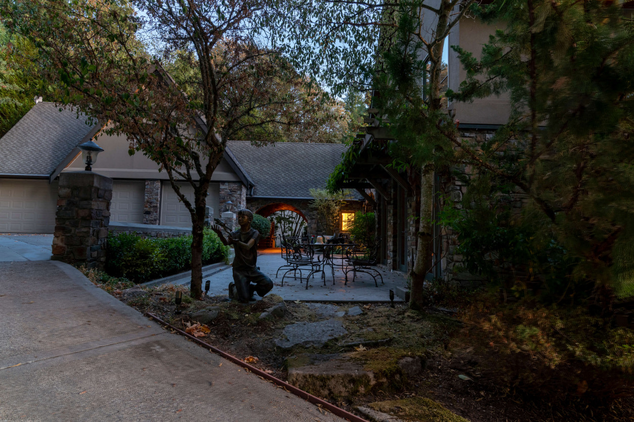 Before Picture of entrance pathway with layered trees and planting beds at a luxury Sammamish estate.