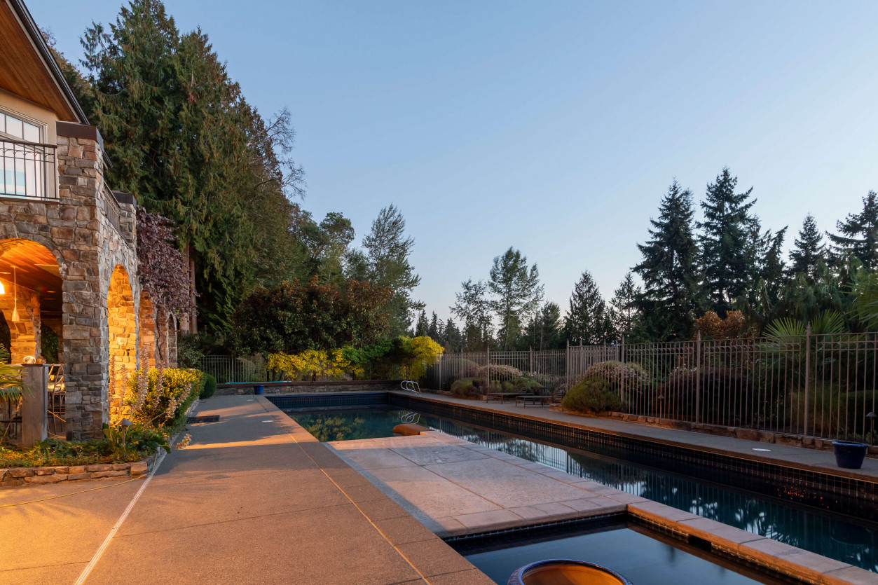Warm pathway lighting along pool deck leading to seating terrace at a Sammamish estate, designed with 2700K LED fixtures.