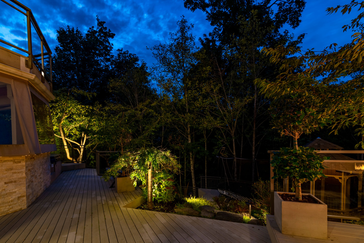 Integrated lighting along deck railings highlighting pathway transition to lower terrace.