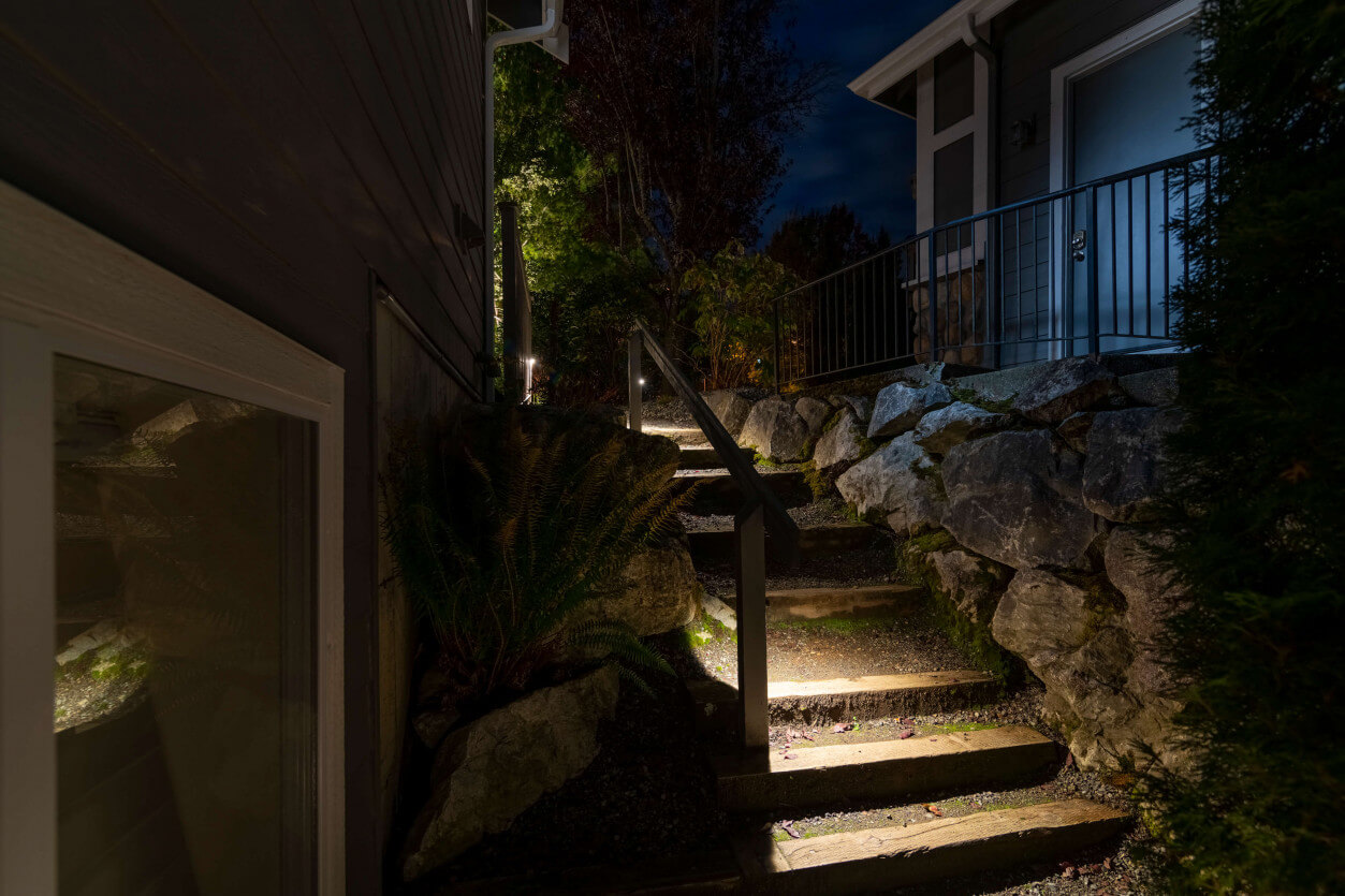 Staircase lighting with recessed step fixtures guiding movement between backyard levels in Sammamish — Northwest Outdoor Lighting 2700K.