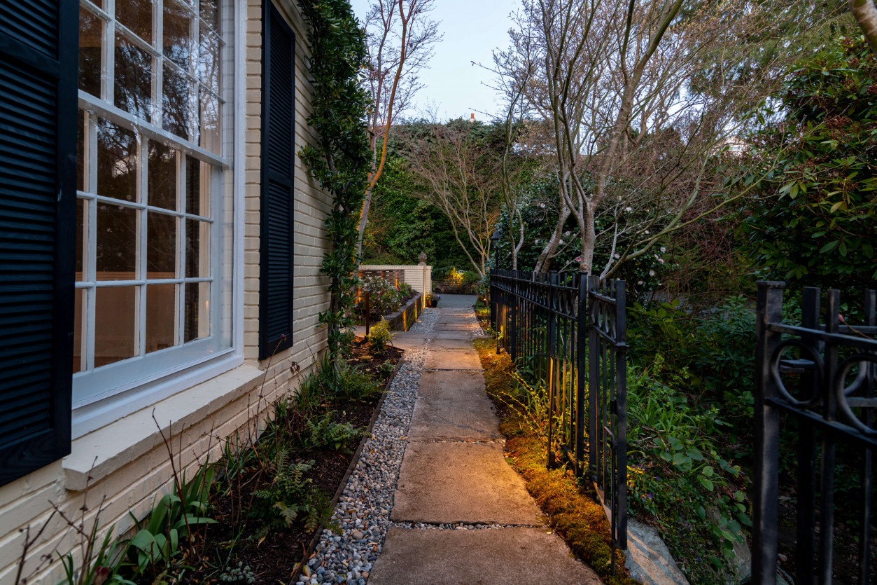 Pathway lighting along lush garden entry in Magnolia Seattle illuminated with warm 2700K outdoor lighting.