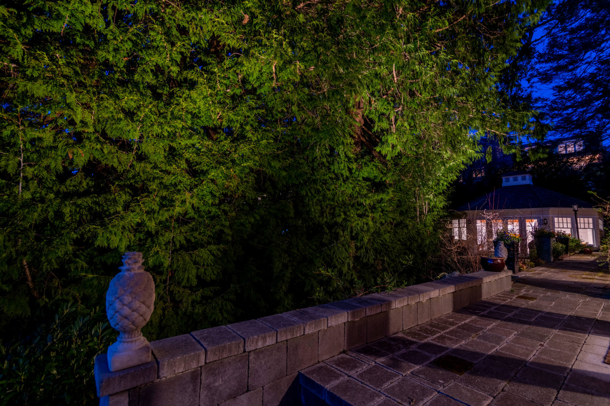 Elevated patio and stone terrace lighting overlooking garden area at Magnolia Seattle property.